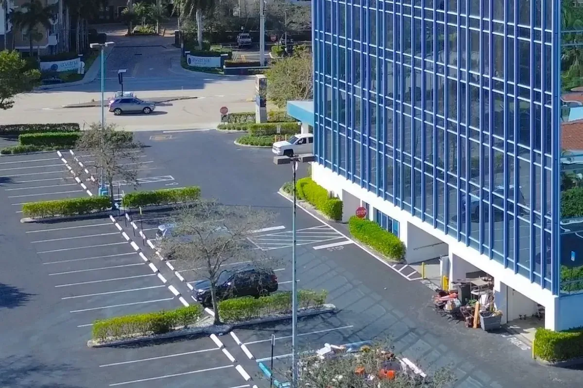 The property seen from the air: the car park, the adjoining street and the flank of the existing office building.