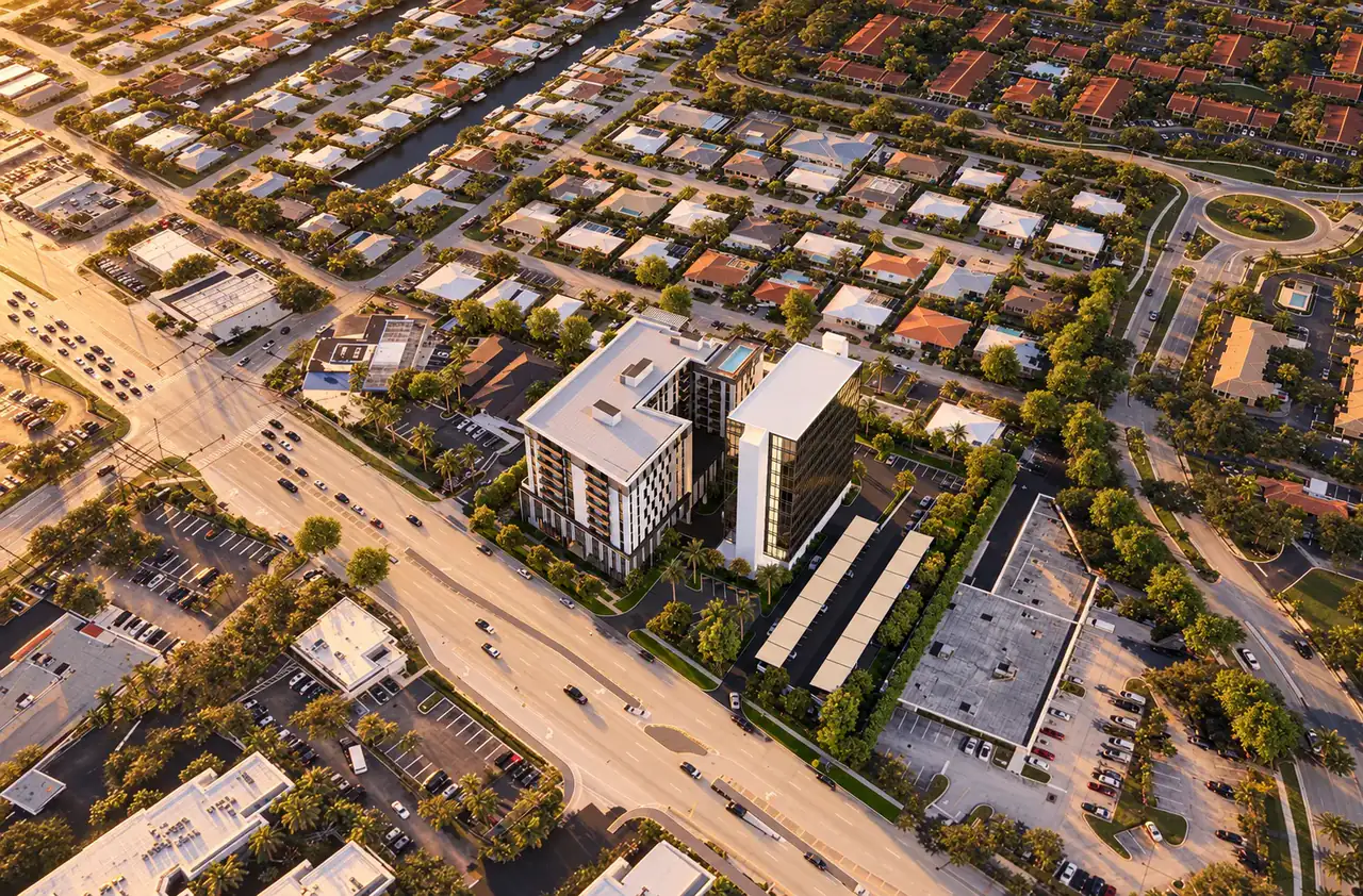 Conceptual visualisation based on R-001: the existing office tower and the proposed residential building from the air, in evening light.
